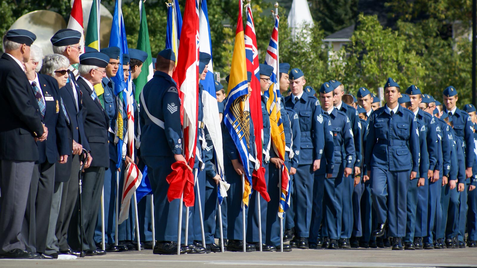 Air Cadets and flag bearers standing in formation at a commemorative ceremony.